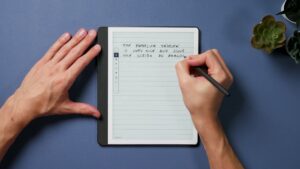 Hand schreibt mit dem Premium-Stift auf einer linierten Notizseite des Kindle Scribe 2024.