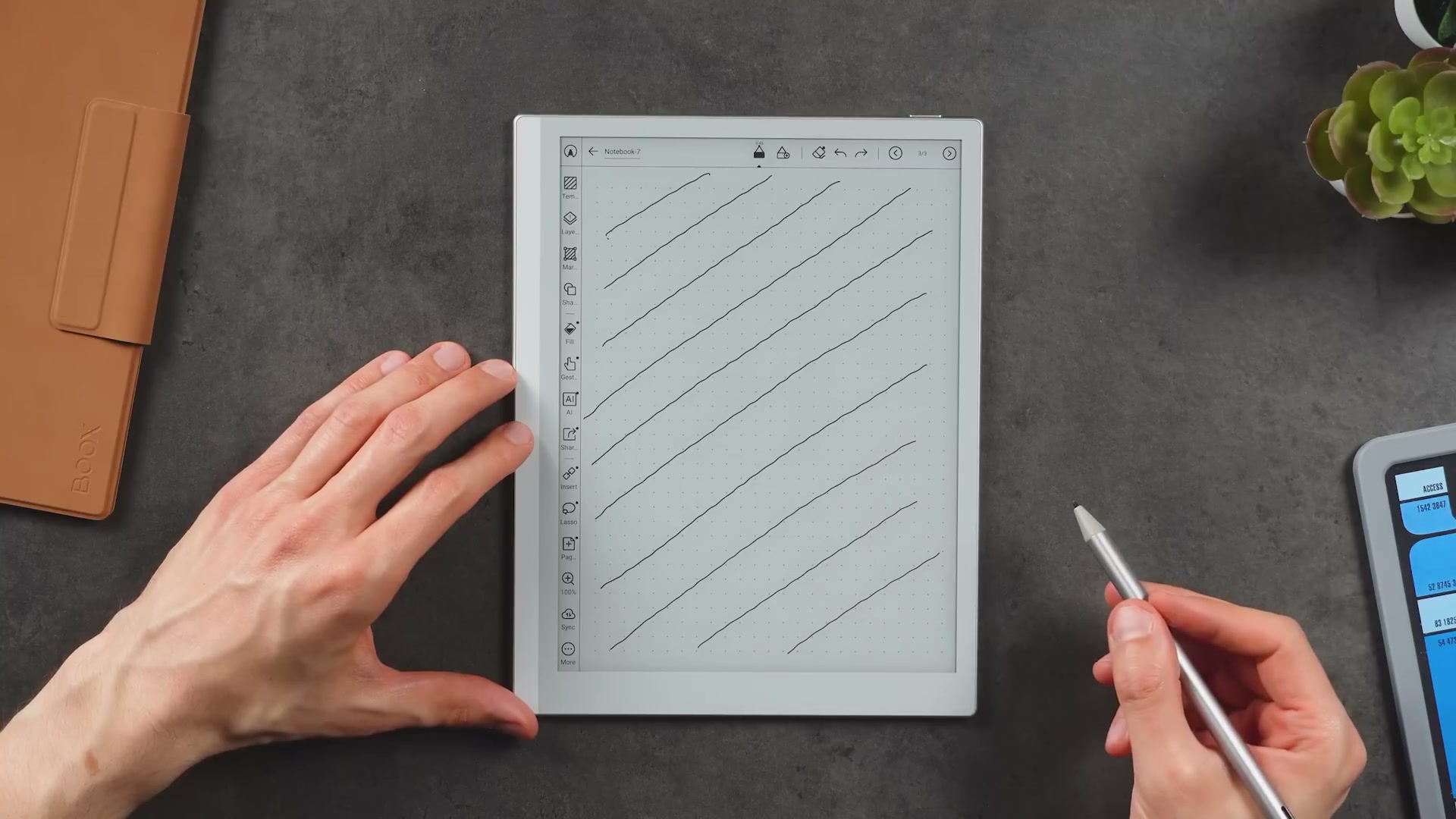 Go 10.3 Gen 2 Lumi mit einer Seite diagonaler Testlinien und InkSense+-Stift in der Hand.