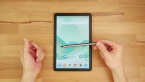 Silberfarbener TCL-Stift waagerecht vor dem vollständig sichtbaren Tablet mit geöffneter Startseite.