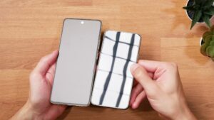 Links streut die matte TCL-Oberfläche das Licht, rechts spiegelt das Galaxy S22 die Lichtquelle deutlich.