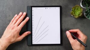 Note Air 5C mit fünf diagonalen Stiftlinien, der schwarze BOOX-Stift wird rechts daneben gehalten.