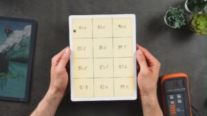 Kindle Scribe mit warm beleuchteter Rasterseite in beiden Händen.