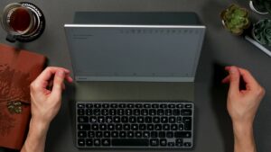 BOOX Note Max im Querformat in einem aufgeklappten Folio, davor eine separate kompakte QWERTZ-Tastatur.