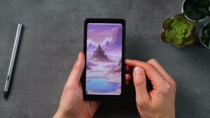 Palma 2 Pro mit violett-blauer Landschaftsillustration; links liegt der BOOX-Stift.