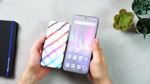 iPhone 13 Pro links und TCL NXTPAPER 60 Ultra rechts unter einem Lichtmuster, das auf dem matten TCL-Display diffus erscheint.