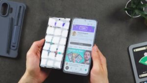 NXTPAPER 70 Pro rechts neben einem glänzenden Smartphone mit starker Fensterreflexion.