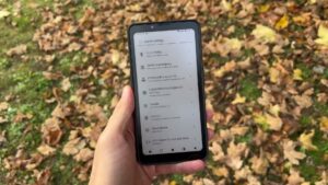 HiBreak Pro Color draußen in einer Hand, mit Systemeinstellungen und Eintrag für den Kundendienst.