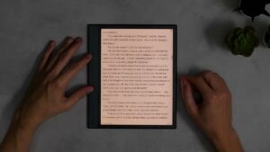 Note Air4 C mit warm beleuchteter Buchseite auf einem abgedunkelten Tisch.